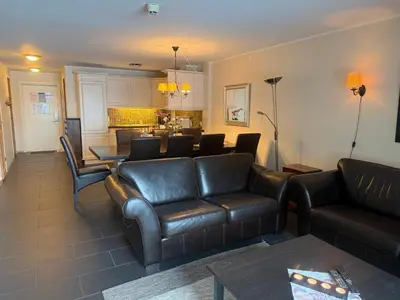 a living room with a leather couch and a table at Enjoy Comfort Wi-Fi, Sauna & More! in Beitostøl