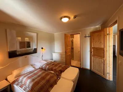 a bedroom with a bed and a door to a bathroom at Enjoy Comfort Wi-Fi, Sauna & More! in Beitostøl