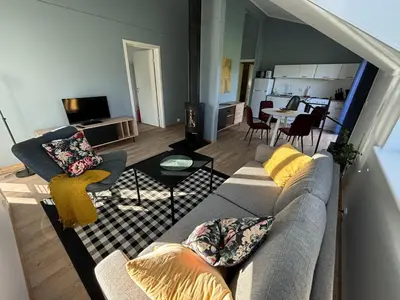 a living room with a couch and a kitchen at Stenegården in Namsos
