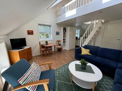 a living room with a blue couch and a table at Stenegården in Namsos