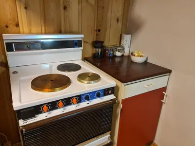 a kitchen with a stove with a pan on it at Hyttepreget overnattingssted in Geilo