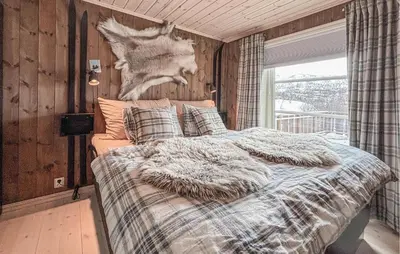 a bedroom with a bed with a deer head on the wall at 4 Bedroom Awesome Home In Vøringsfoss in Garden