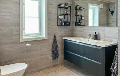 a bathroom with a sink and a toilet and a mirror at 4 Bedroom Awesome Home In Vøringsfoss in Garden