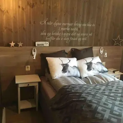 a bedroom with a bed with two animals on pillows at Hytte med god standard in Stranda