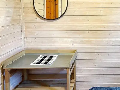 a table in the corner of a room with a mirror at 4 person holiday home in Lysøysundet in Teksdal
