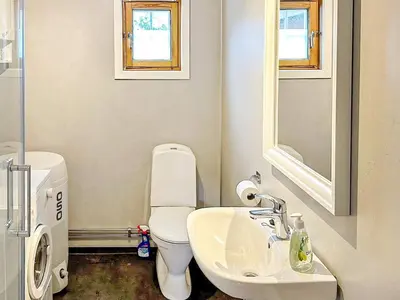 a white bathroom with a toilet and a sink at 4 person holiday home in Lysøysundet in Teksdal