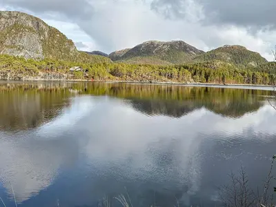 a view of a lake with mountains in the background at 4 person holiday home in Lysøysundet in Teksdal