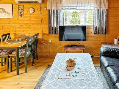 a living room with a table and a television at 4 person holiday home in Lysøysundet in Teksdal