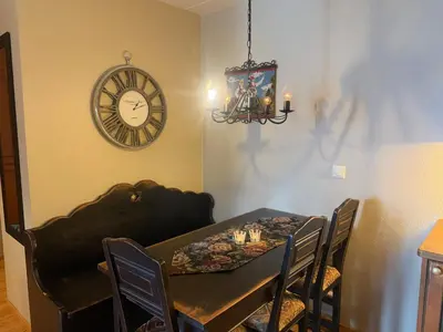 a dining room with a table and a clock on the wall at Ideal Base For Exploring 2 Bedrooms & Balcony in Beitostøl