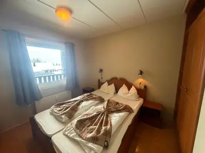 a bedroom with a bed with a blanket on it at Ideal Base For Exploring 2 Bedrooms & Balcony in Beitostøl