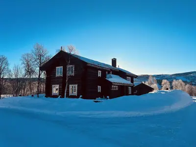 a house covered in snow with a pile of snow at Geilo centrum - cozy apartment - central location in Geilo