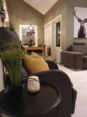a living room with a table and a couch at Seaside cottage with hot tub and sauna sleeps 11 in Forland
