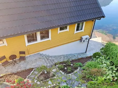 an aerial view of a yellow house with a garden at 6 person holiday home in Bygstad in Bygstad