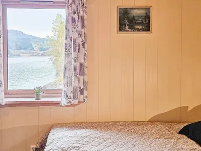 a bedroom with a window with a view of the water at 6 person holiday home in Bygstad in Bygstad