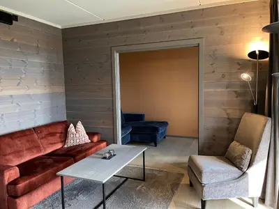 a living room with a couch and a table at Riddertunets utsikt til Slettefjell in Beitostøl