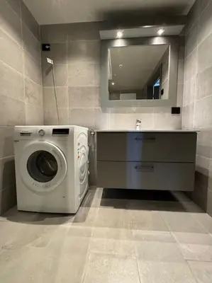 a bathroom with a washing machine and a mirror at Riddertunets utsikt til Slettefjell in Beitostøl