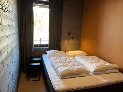 a bed sitting in a room with a window at Riddertunets utsikt til Slettefjell in Beitostøl