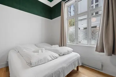 a white bed in a room with a window at Experience the luxury lifestyle 100m from Bryggen! in Bergen