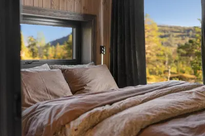 a bed in front of a window with a view at Stryn Wiew Logde Tverrfjellet in Stryn