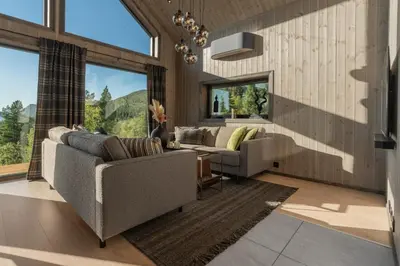 a living room with two couches and large windows at Stryn Wiew Logde Tverrfjellet in Stryn