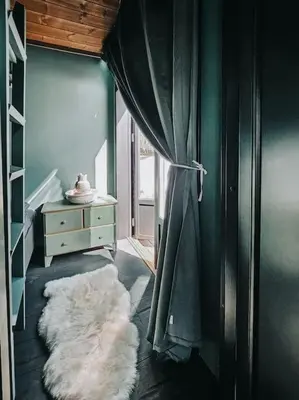 a room with a curtain and a white rug at Cozy Mountain Cottage with beautiful views & Sauna in Beitostøl