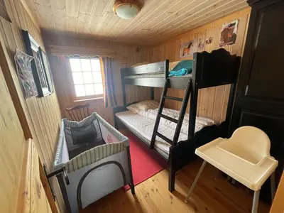 a small room with a bunk bed and a chair at Springaren - cabin close to Gaustatoppen in Tuddal