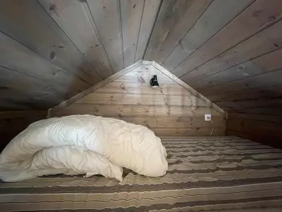 a bed with a white comforter in a room at Springaren - cabin close to Gaustatoppen in Tuddal