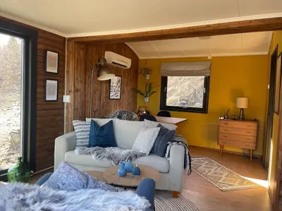 a living room with a couch and a table at Koselig gårdshus in To