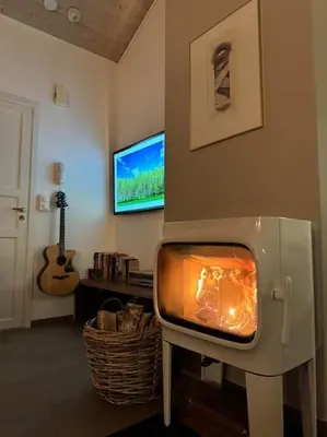 a fireplace in a living room with a tv at Nydelig leilighet i Bakklandet in Trondheim