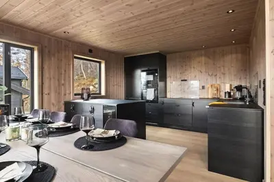 a dining room with a table and a kitchen at Hytte med fjellutsikt til nydelig natur in Sogndal