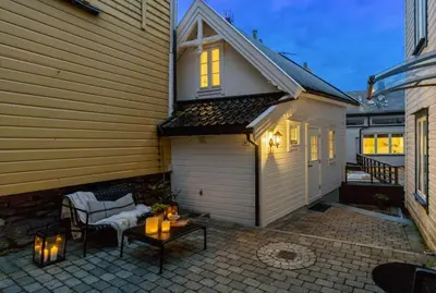 a patio with a table and chairs and a house at Stay l The Town House in Bergen