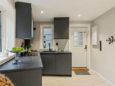 a kitchen with gray cabinets and a bowl of fruit on the counter at Stay l The Town House in Bergen