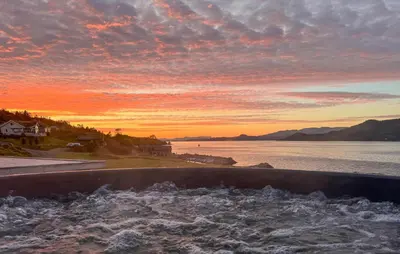 a sunset over a body of water with waves at 5 Bedroom Lovely Home In Ølensvåg in Vaka