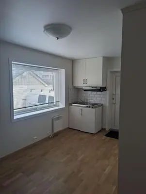 an empty room with a kitchen and a window at Leilighet sentralt i Stryn in Stryn