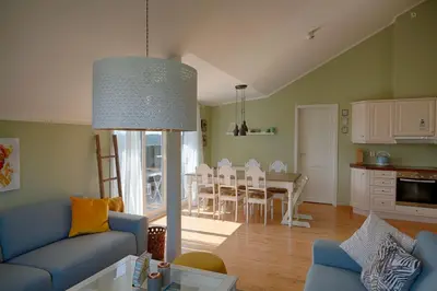a living room with a blue couch and a table at Bright and Modern penthouse apartment in Beitostøl