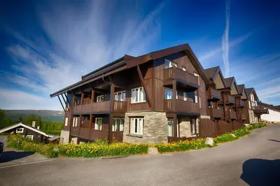 a large wooden building with a lot of windows at Bright and Modern penthouse apartment in Beitostøl