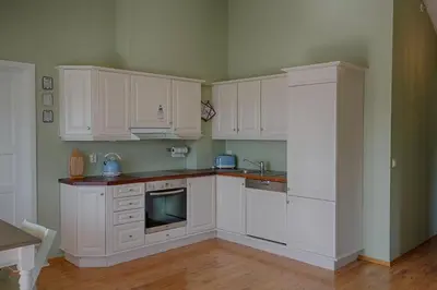 a kitchen with white cabinets and a sink at Bright and Modern penthouse apartment in Beitostøl