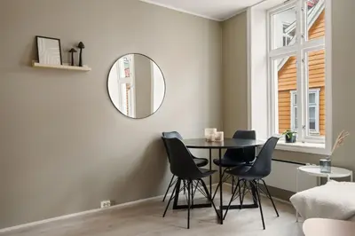 a dining room with a table and chairs and a mirror at Bergen Beds Apartments I Luxury 250m from Bryggen in Bergen