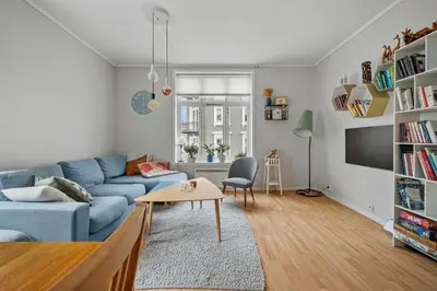 a living room with a blue couch and a table at Your Local Bergen Dream In The Heart Of The city in Bergen