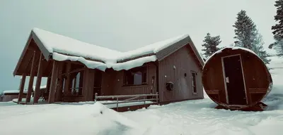 a wooden cabin with snow on the roof at Snowcake Cottage in Sør-Fron