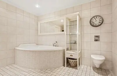 a bathroom with a tub and a toilet and a clock at Villa Freya with stunning sea view in Kristiansund