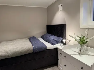 a small bedroom with a bed and a dresser at StarView Trolltunga Apartment in Odda