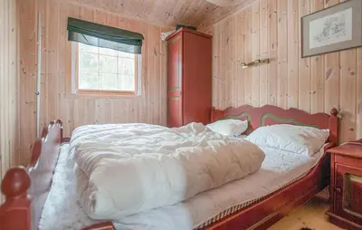 a large bed in a room with wooden walls at 5 Bedroom Gorgeous Home In Engerdal in Nymoen