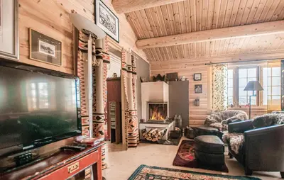 a living room with a television and a fireplace at 5 Bedroom Gorgeous Home In Engerdal in Nymoen