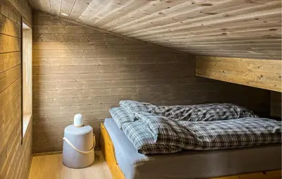 a bed in a room with wooden walls at Cozy Home In Ålen With Wifi in Ålen