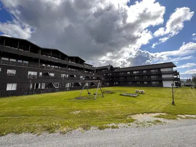 a school yard with a playground in front of a building at Enjoy Scenic Views From Your Balcony in Beitostøl