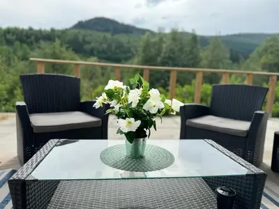 a glass table with a vase of white flowers on it at Dalen Apartment in Stranda