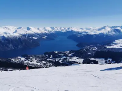 a view of a snow covered mountain with a lake at Dalen Apartment in Stranda