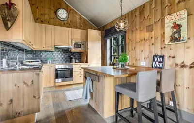 a kitchen with wooden cabinets and a counter with a chair at 4 Bedroom Gorgeous Home In Rauland in Rauland