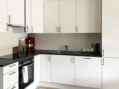 a kitchen with white cabinets and a sink at 4 person holiday home in Frekhaug in Hordvik